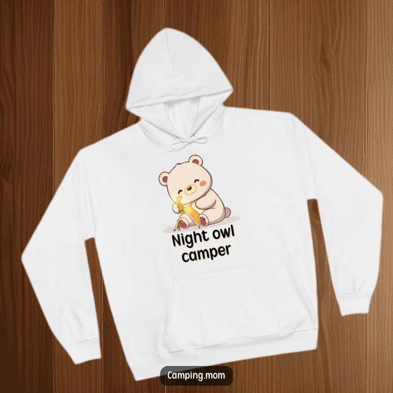 Funny hoodie of a mama bear illuminated by a headlamp, happily pitching a small tent, celebrating outdoor living.