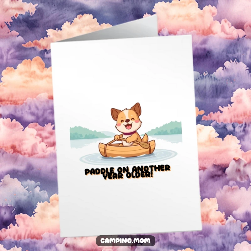 Funny free printable birthday card shows a happy dog joyfully paddling a canoe across a calm, reflective lake.